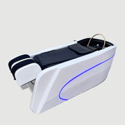 Modern white reception desk with blue LED lights in a room with white curtains and a plant.